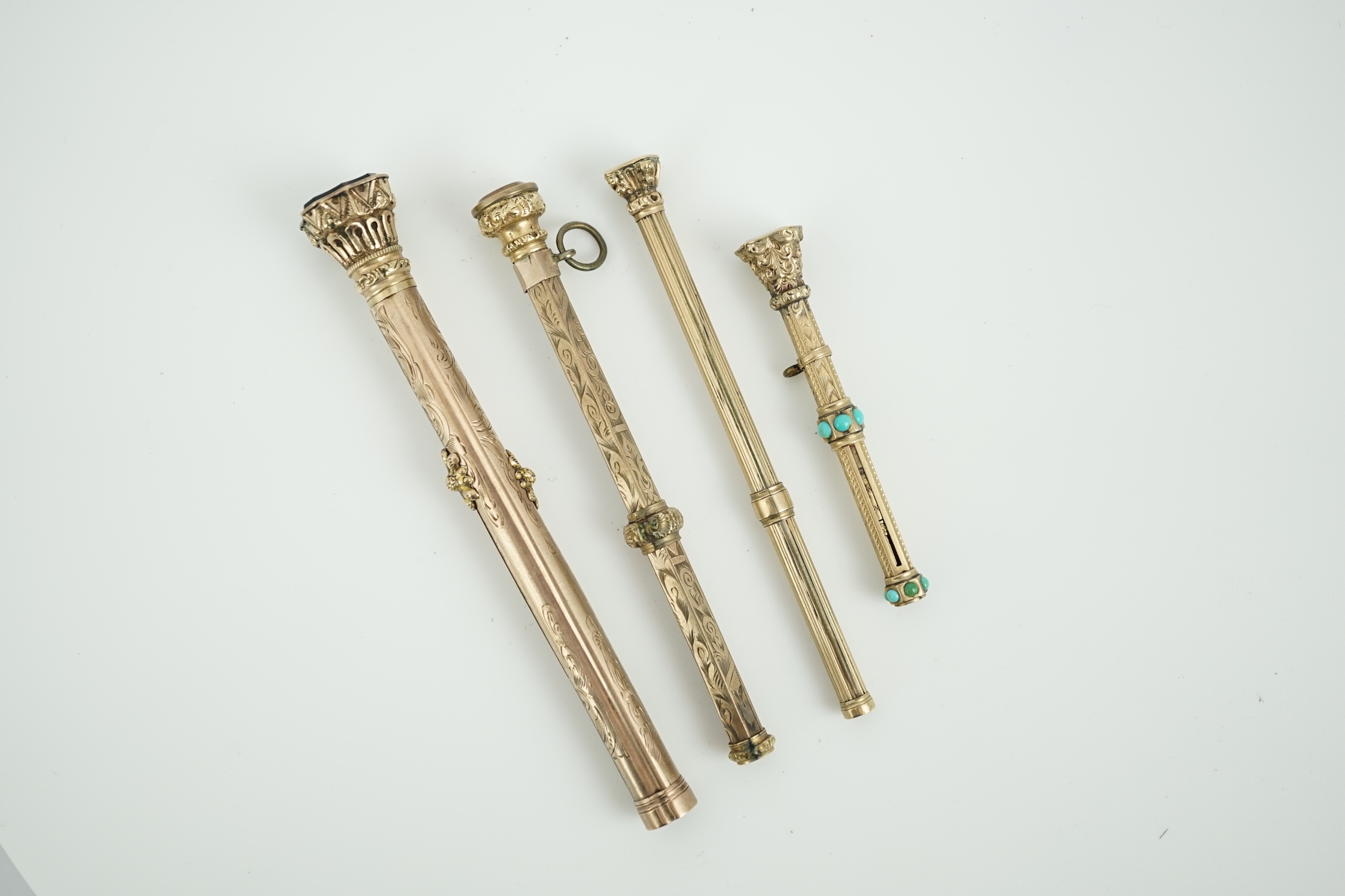 Four assorted late 19th/early 20th century yellow metal overlaid and gem set propelling pencils, largest set with bloodstone with pen and pencil, 97mm.